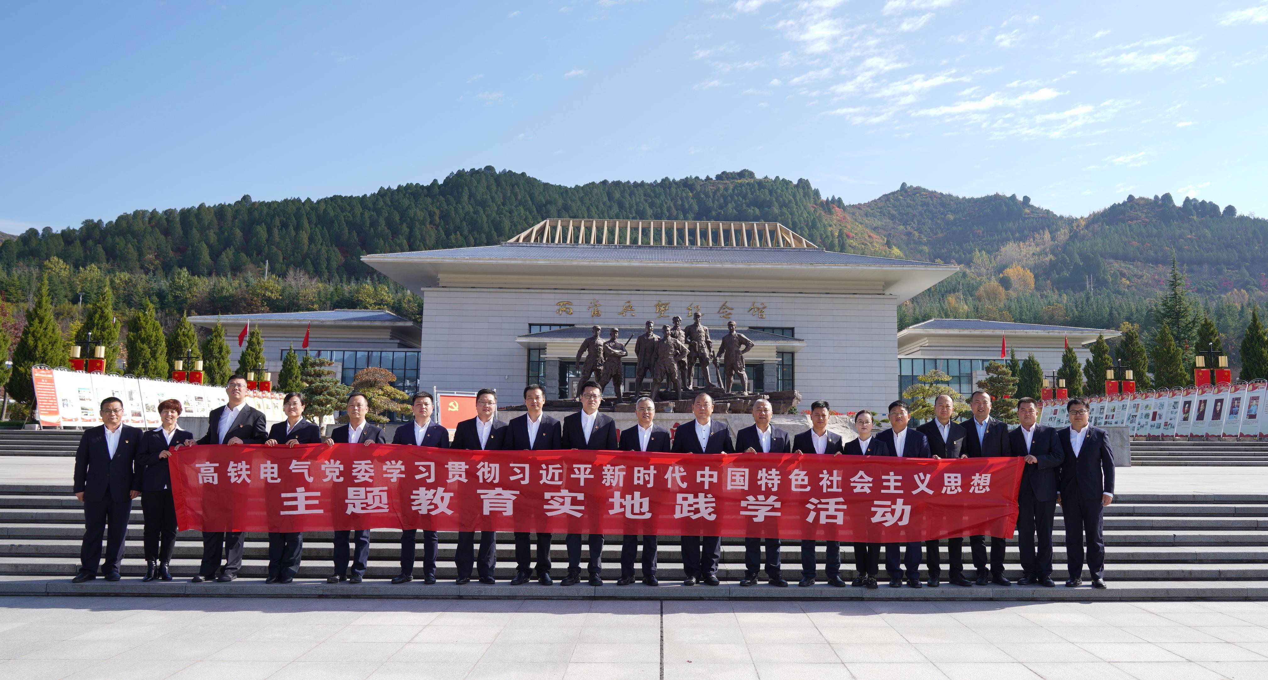 纪念馆外横幅合影.jpg